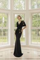 Black Isabelle crepe gown with Emmanuellette cape, elegant evening dress by 21Six, featuring flowing fabric and stylish design.
