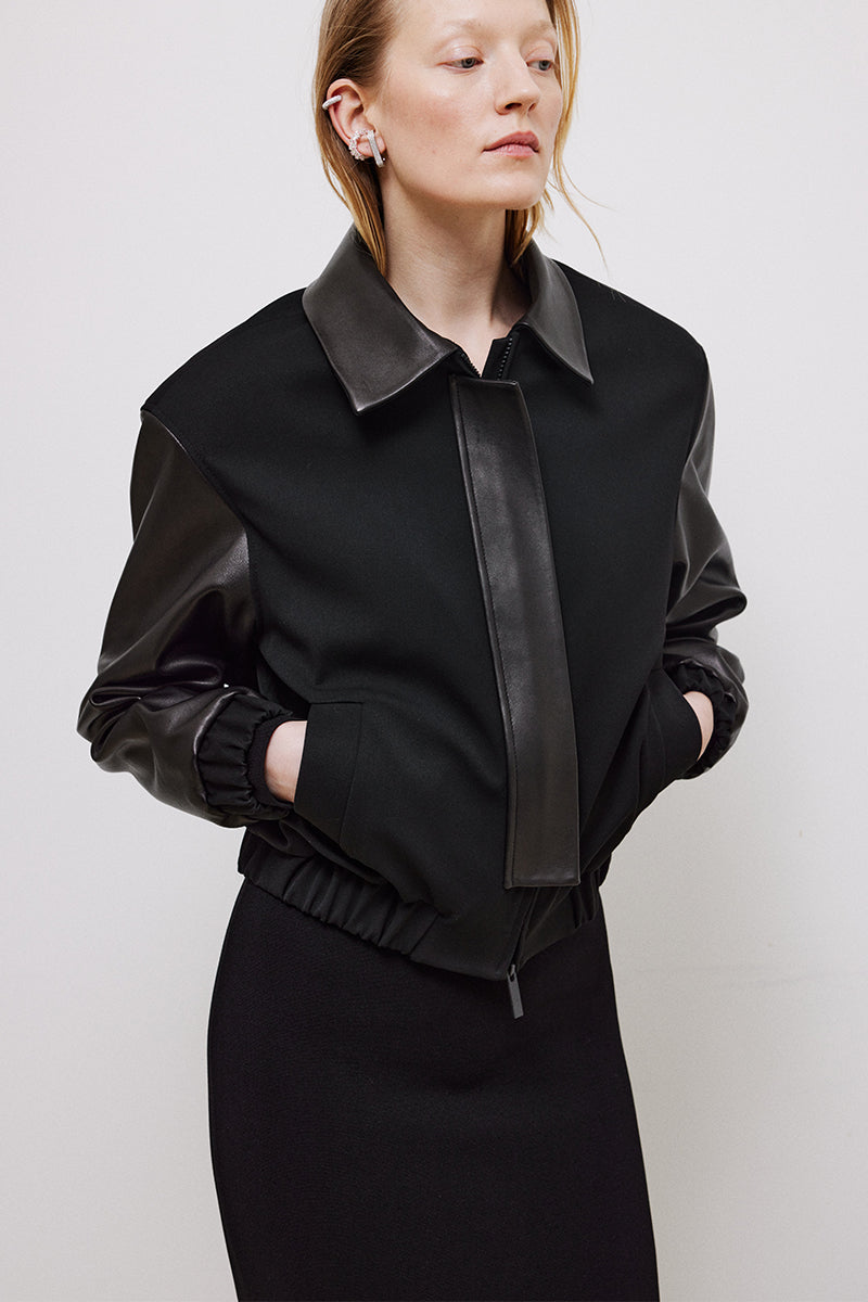 Black cropped relaxed fit bomber jacket by TAGG, shown with front view and minimal detailing in the image.