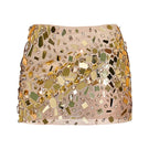 Gold embellished mini skirt by CEM featuring shiny gold accents and a fitted waistband, shown on a model.