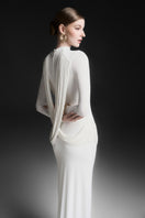 Maison Des Copains white draped floor-length gown, elegant design with flowing fabric and a sophisticated silhouette.