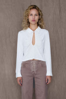 White GAB top by TT Studios, featuring a stylish design with a fitted silhouette and soft fabric visible in the image.