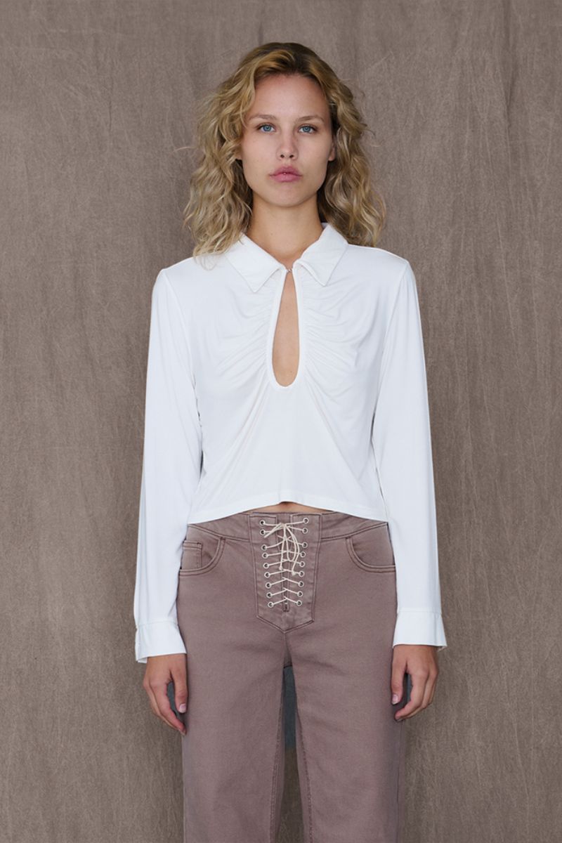 White GAB top by TT Studios, featuring a stylish design with a fitted silhouette and soft fabric visible in the image.
