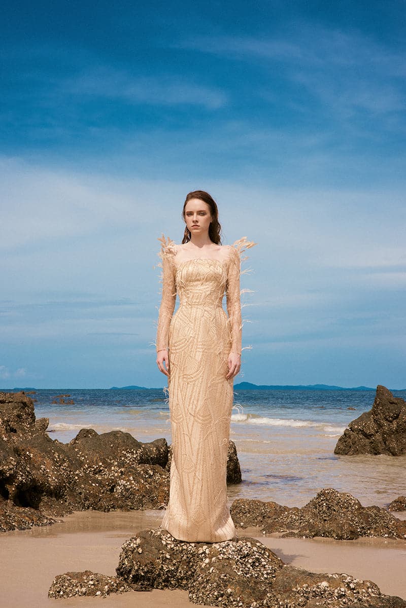 Beige Emily Crystal Lace Feather Gown by 21Six, featuring intricate lace details and feather accents, shown on a model.
