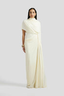 Deme By Gabriella Luciana maxi dress in off-white fabric, flowing silhouette, sleeveless design, and elegant style.