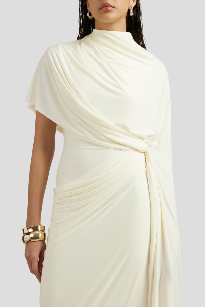 Deme By Gabriella Luciana maxi dress in off-white with flowing fabric and elegant design, shown on a model.