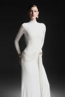 White Corvina draped floor-length gown by Maison Des Copains, elegant formal dress with flowing fabric and sophisticated style.