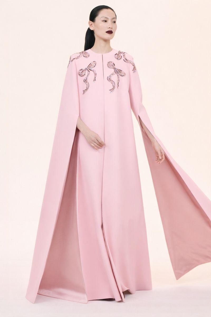 Nihan Peker Aura Pink Cape Gown displayed on a mannequin, featuring elegant pink fabric and flowing cape design.