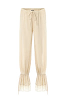 Cream SCYLLA pants by IKINITA, featuring a stylish design with a comfortable fit, displayed on a mannequin.