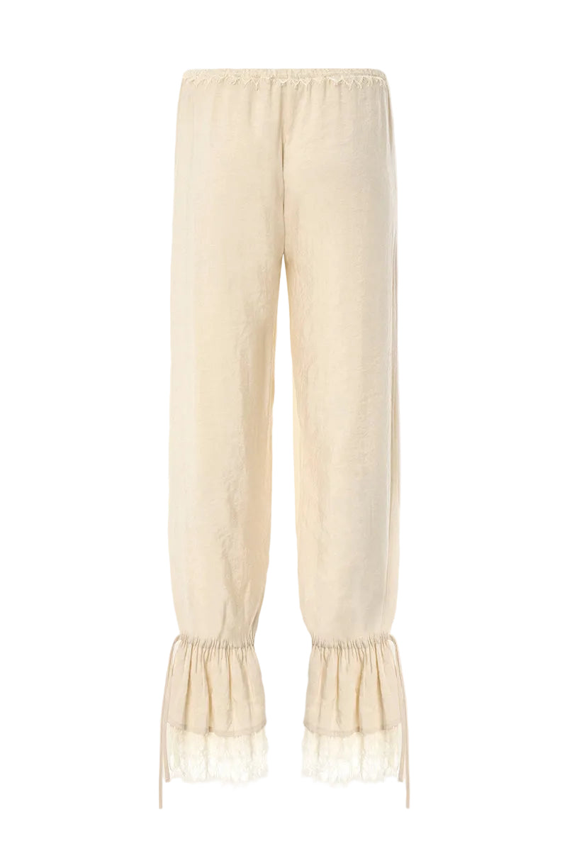 Cream Scylla pants by IKINITA, featuring a stylish fit with visible stitching and a relaxed, comfortable design.