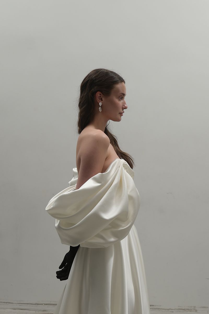 Off-White Volume Sculpted Gown by Monetre, featuring a flowing, sculpted design in a luxurious fabric, worn by a model on the runway.