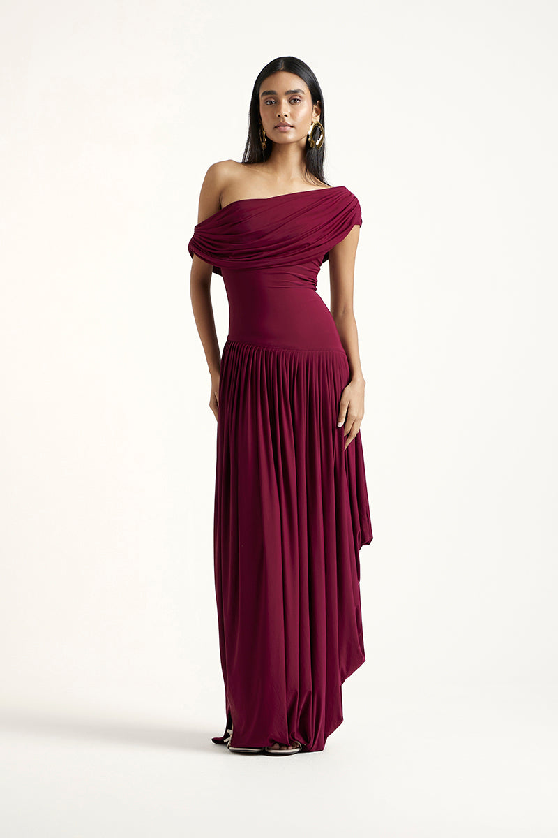 Deme By Gabriella Cassidy maxi dress in aubergine, flowing fabric with a stylish silhouette, displayed on a hanger.