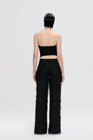Nué Veneda corset top featuring structured design and adjustable straps, shown on a model in a stylish resort setting.