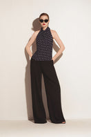 Black Valenciani halter neck backless top displayed on a model, showcasing a stylish sleeveless design with a fitted silhouette.