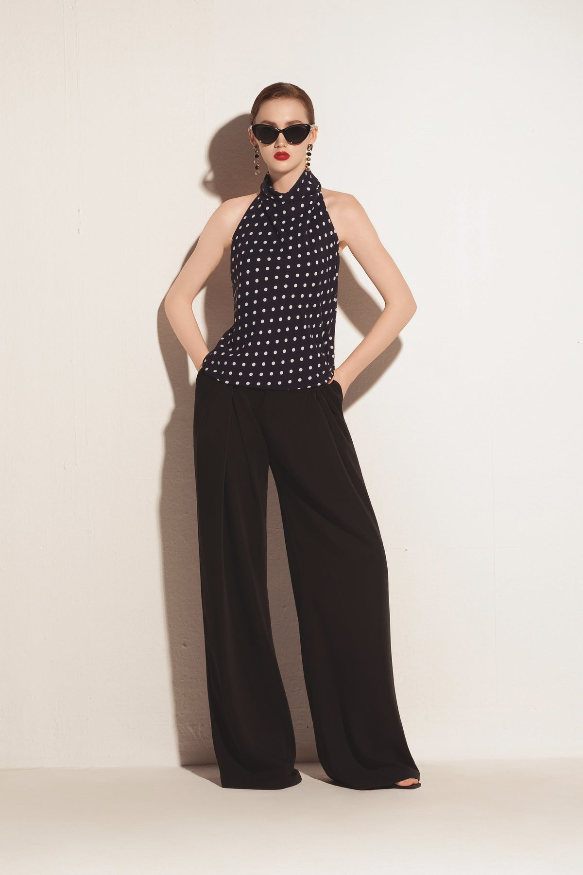 Black Valenciani wide leg trousers displayed on a model, showcasing the relaxed fit and flowing fabric of the stylish pants.