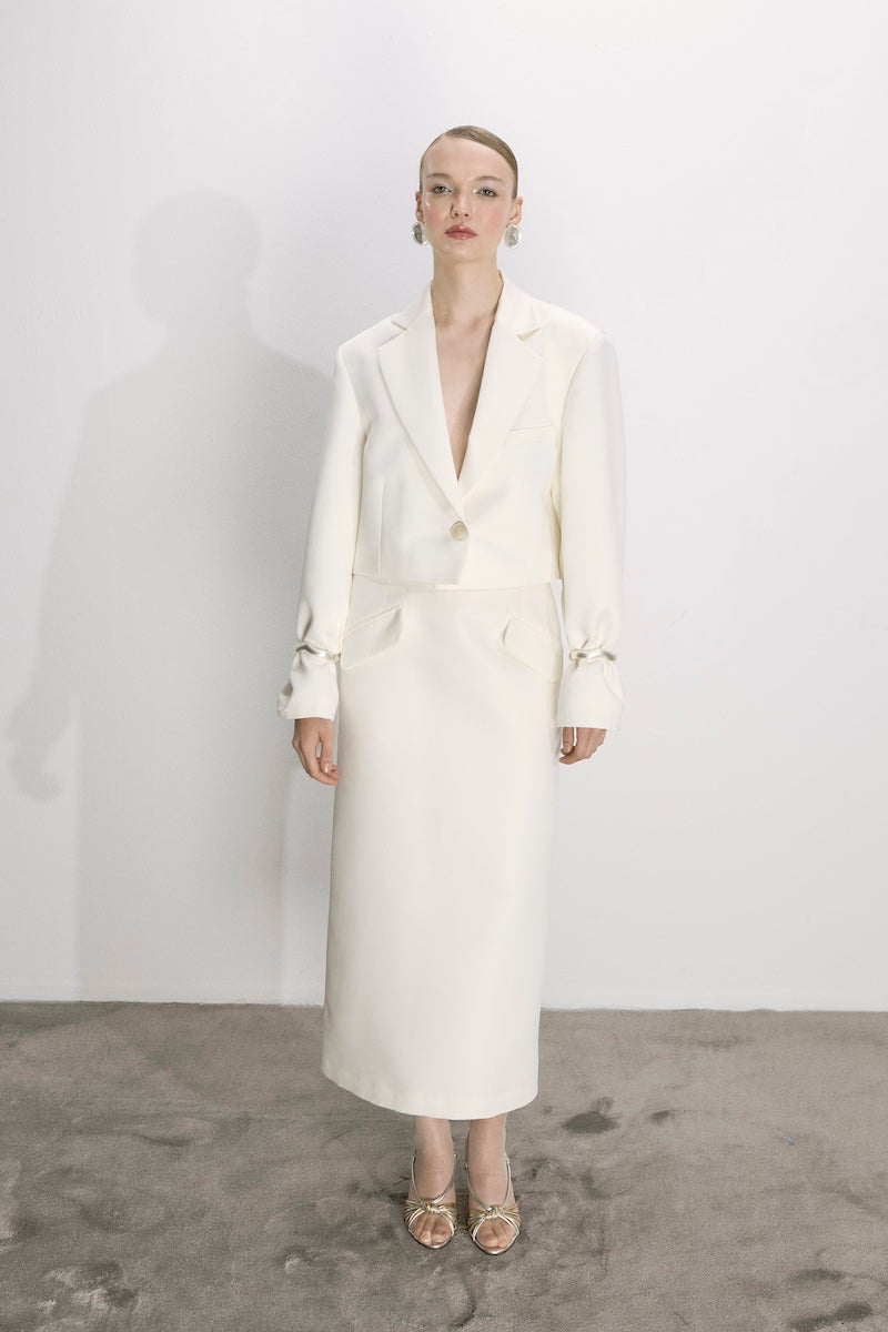 Nazlı Ceren vanilla ice satin cropped jacket with long sleeves and collar, styled on a model for a fashion photoshoot.