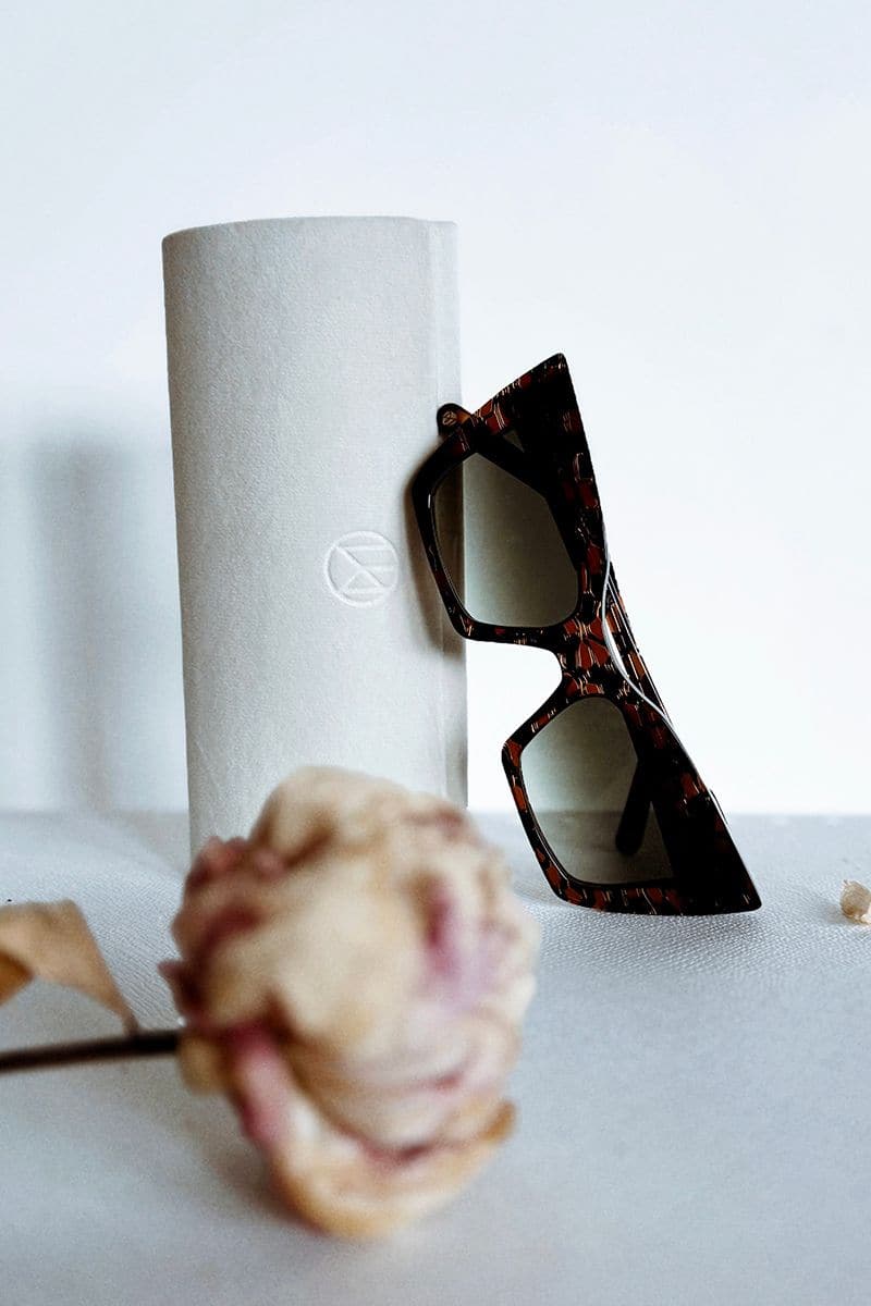 Dark crocodile-patterned Moy Atelier sunglasses with sleek black frames and tinted lenses, stylishly displayed.