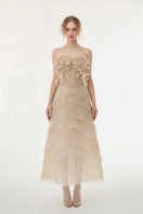Beige tulle and organza gown by 21Six, featuring a flowing design with elegant fabric details and a sophisticated silhouette.