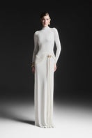 Maison Des Copains white Corvina draped floor-length gown shown on a model, featuring elegant flowing fabric and sophisticated style.