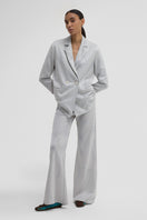 Maccapani easy pants in off-white silver fabric, featuring a relaxed fit and modern style, shown on a model.