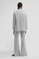 Maccapani Easy pants in off-white silver fabric, shown folded with smooth, modern style in the image.