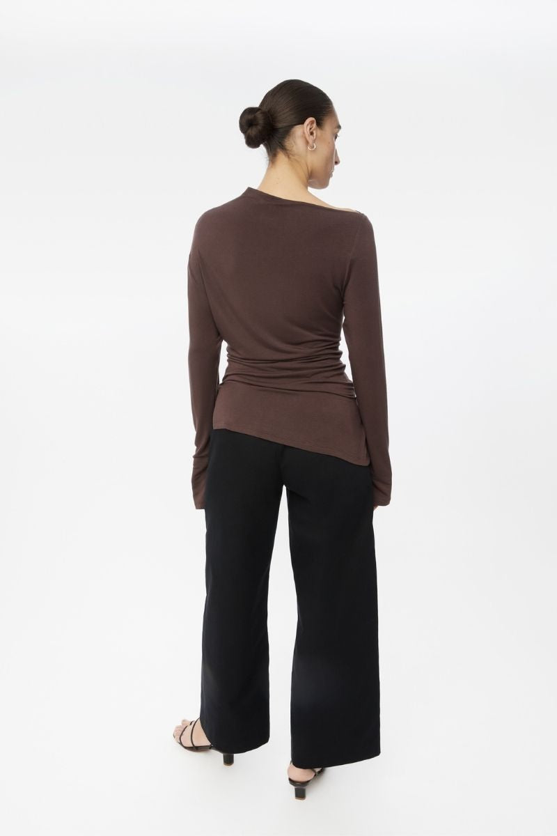 Dāl the Label modal asymmetric knit top featuring a unique draped design and soft, lightweight fabric in neutral tones.