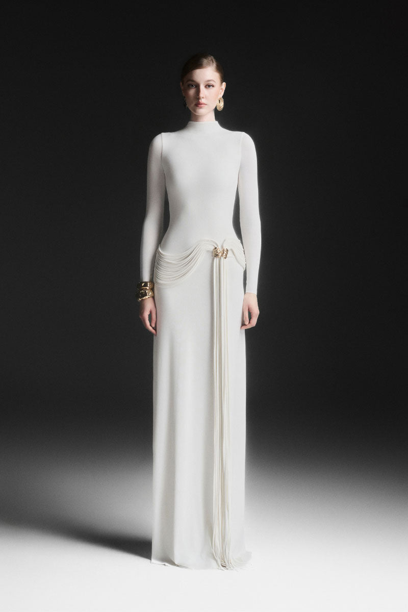 White Corvina draped floor-length gown by Maison Des Copains, elegant evening dress with flowing fabric and sophisticated style.