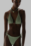 Baobab Kaiabikini bottom in jade and indigo with side tie straps, worn on a model for a stylish beachwear look.