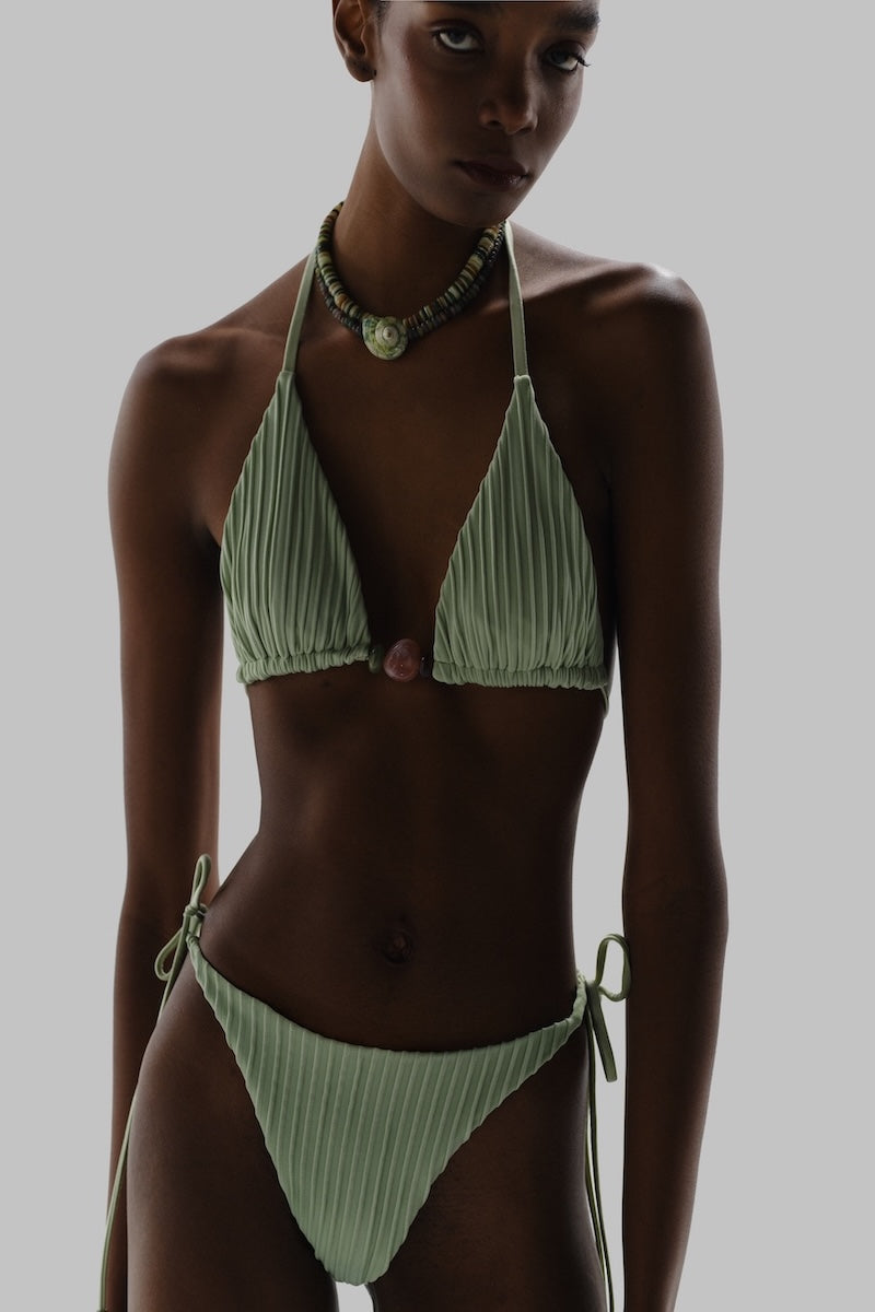 Baobab Kaiabikini bottom in jade and indigo with side tie straps, worn on a model for a stylish beachwear look.