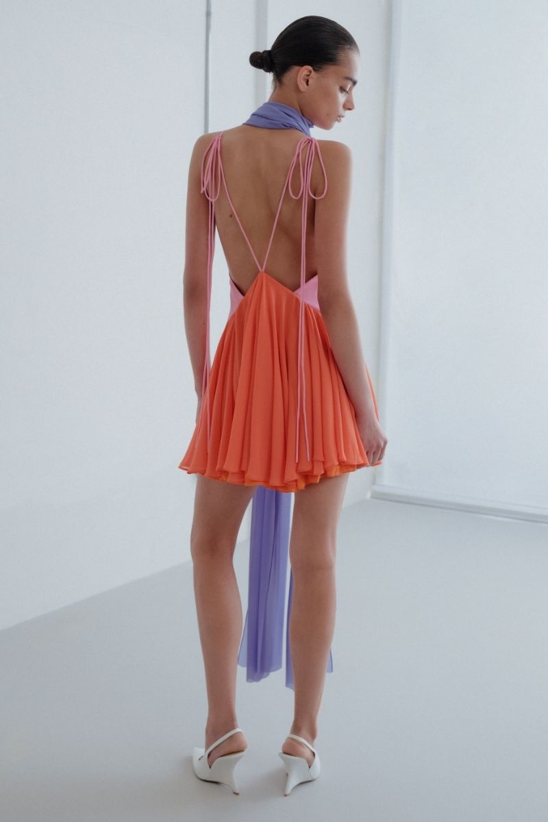 Sisters Kimberly mini dress in peachy pink with a fitted bodice and flared skirt, perfect for summer occasions.