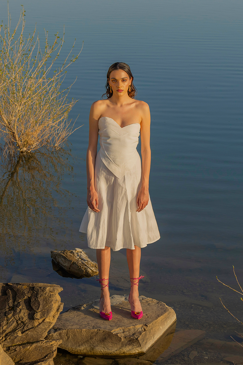 Liya white sweetheart top with a fitted bodice and delicate straps, showcased on a flat lay with soft fabric background.