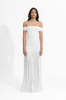 Deme By Gabriella Maria White Maxi Dress displayed on a hanger, featuring flowing fabric and elegant design.