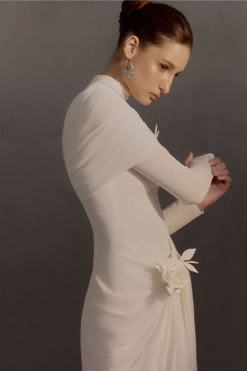 White Plan Jacqueline gown displayed on a hanger, featuring elegant fabric and detailed design suitable for formal occasions.