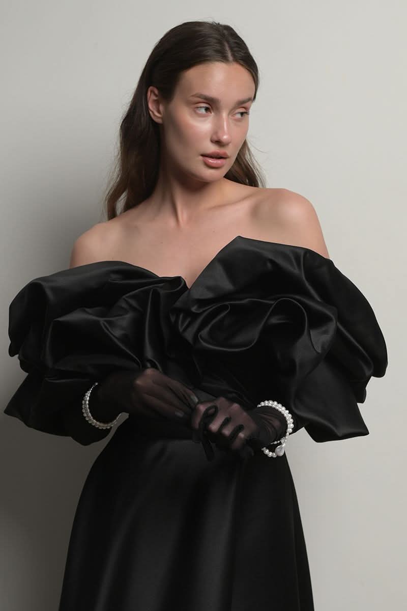 Black Monetre corset gown with meringue flounces, featuring a fitted bodice and flowing skirt with layered ruffles.