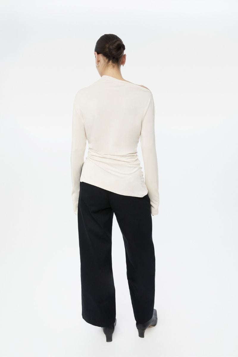 Dāl the Label modal asymmetric knit top featuring a stylish, relaxed fit with a unique draped design and soft fabric.