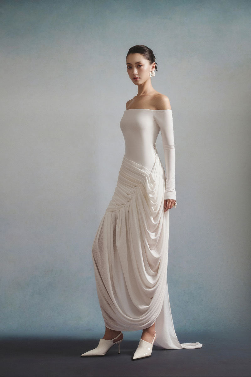 White Plan AURÉLIA draped maxi dress with flowing fabric and elegant design, shown on a mannequin with a neutral background.