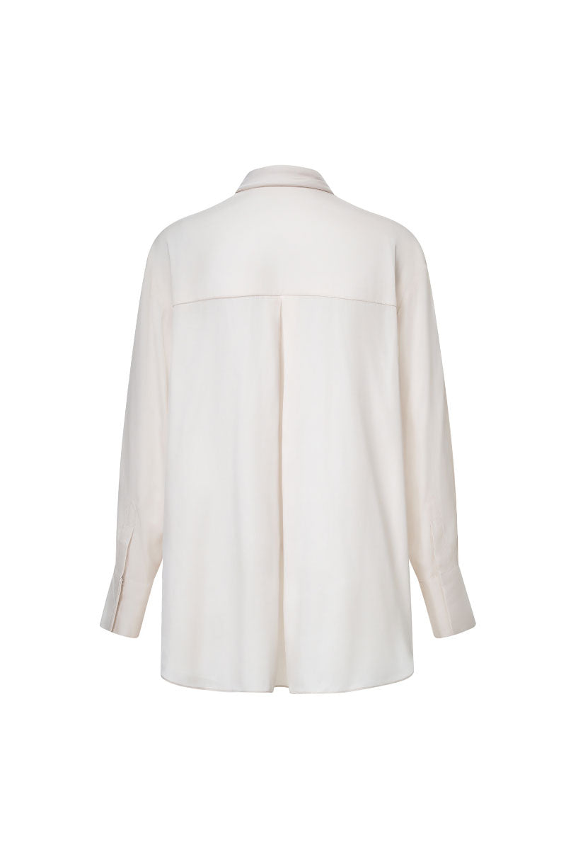 Ivory satin twilly shirt by Levia featuring a smooth, shiny fabric with a stylish tie detail at the collar.