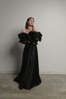 Black Monetre corset gown with meringue flounces, featuring a fitted bodice and flowing skirt with layered ruffles.