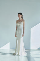 JINSUN botanical embellished ivory cupro gown displayed on a hanger with floral details and flowing fabric.