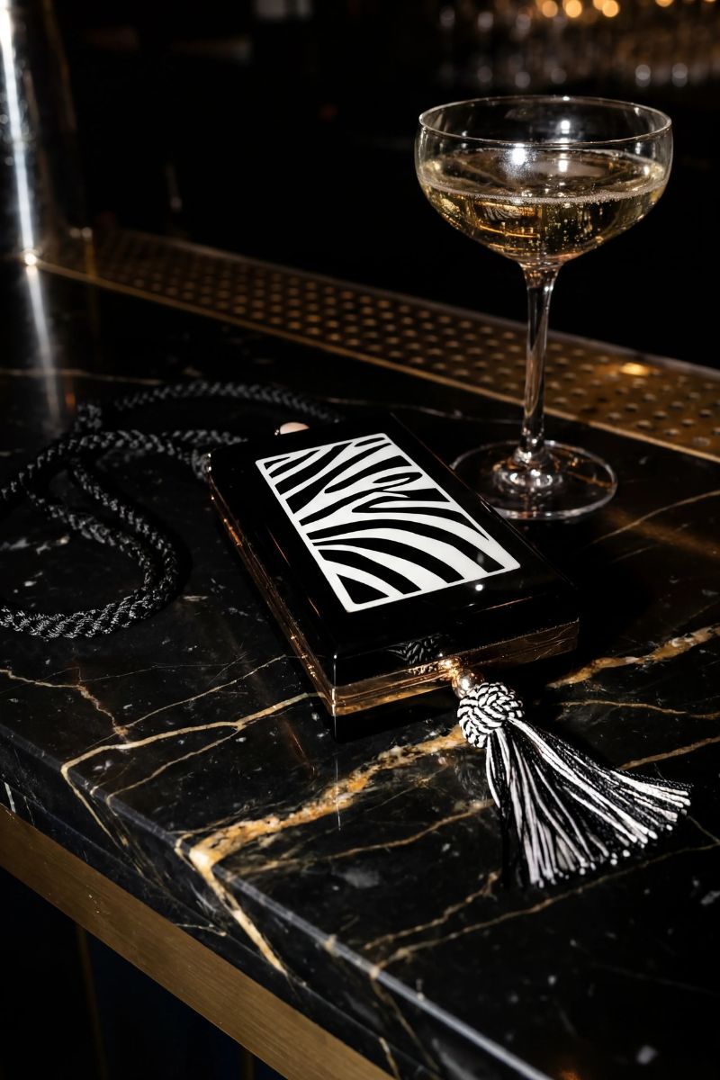 Waiwai Rio zebra print trapezio shoulder bag with structured design and top handle, featuring bold black and white zebra pattern.