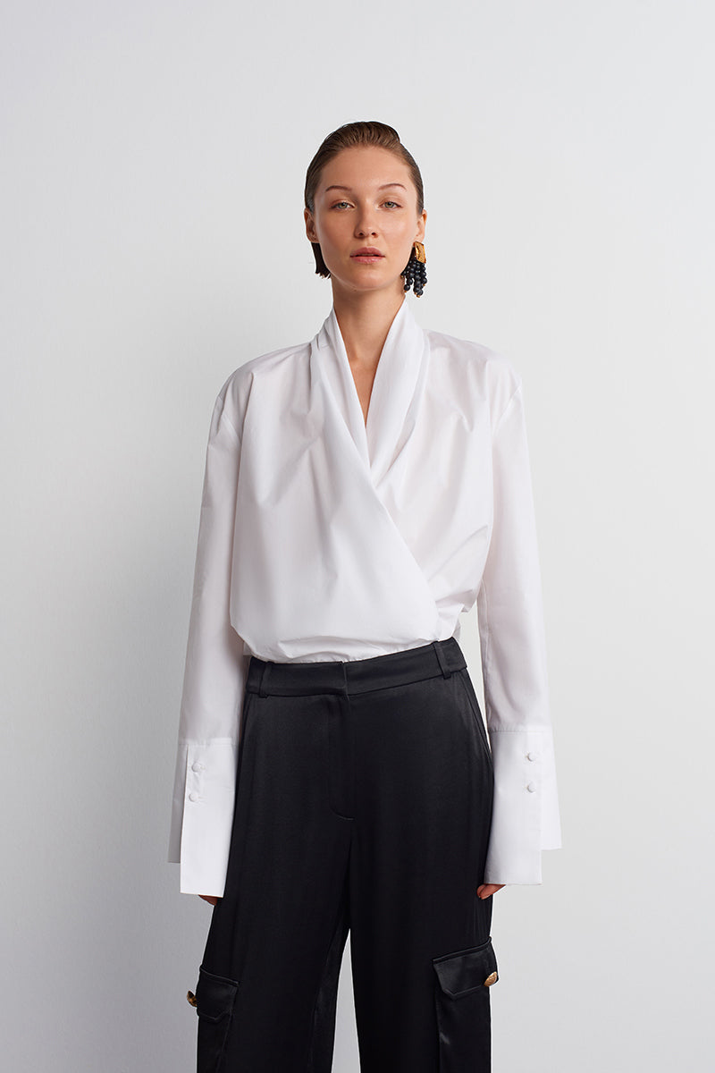 White historical shirt by Acaria Studio featuring classic design, long sleeves, and button-up front, displayed on a hanger.