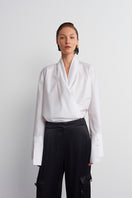 White historical shirt by Acaria Studio featuring classic design, long sleeves, and button-up front, displayed on a hanger.