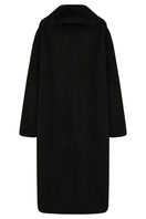 Black oversized shearling coat by JINSUN, showing the plush collar and relaxed fit on a model.