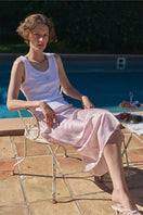 Pink silk bias midi skirt from Not Just Pajama, made of 22 MOMME mulberry silk, shown flat with a smooth, flowing design.