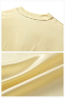 Soft butter yellow silk robe from Not Just Pajama's Timeless Collection, shown draped elegantly on a hanger.