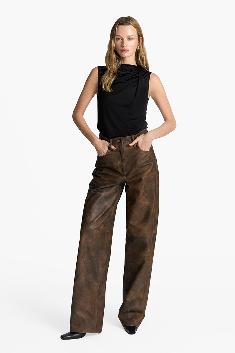 Acaria Studio root washed leather pants shown on a model, featuring a sleek, fitted design and natural leather texture.