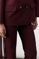 Nazlı Ceren Arced Bordeaux trousers with a tailored fit, featuring a sleek design and subtle detailing on the fabric.