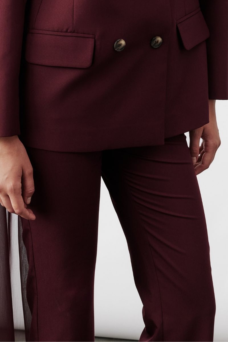 Nazlı Ceren Arced Bordeaux trousers with a tailored fit, featuring a sleek design and subtle detailing on the fabric.