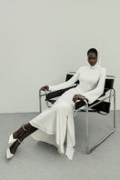 Khanum's white Keli dress, a stylish maxi dress with flowing fabric and elegant design, displayed on a hanger.