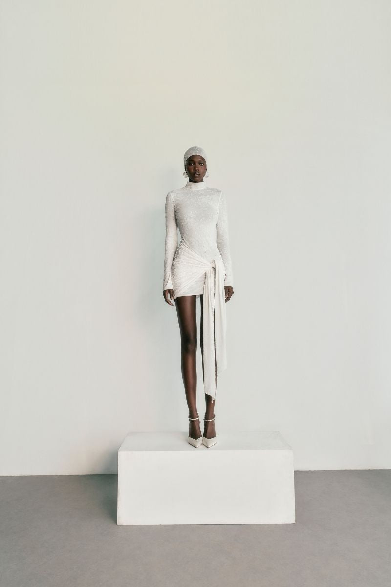 Khanum's KALESY mini dress in white, sleeveless with a fitted silhouette, displayed on a hanger.