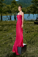 Pink off-shoulder pleated gown by Le Thanh Hoa featuring elegant design and flowing fabric, perfect for formal occasions.